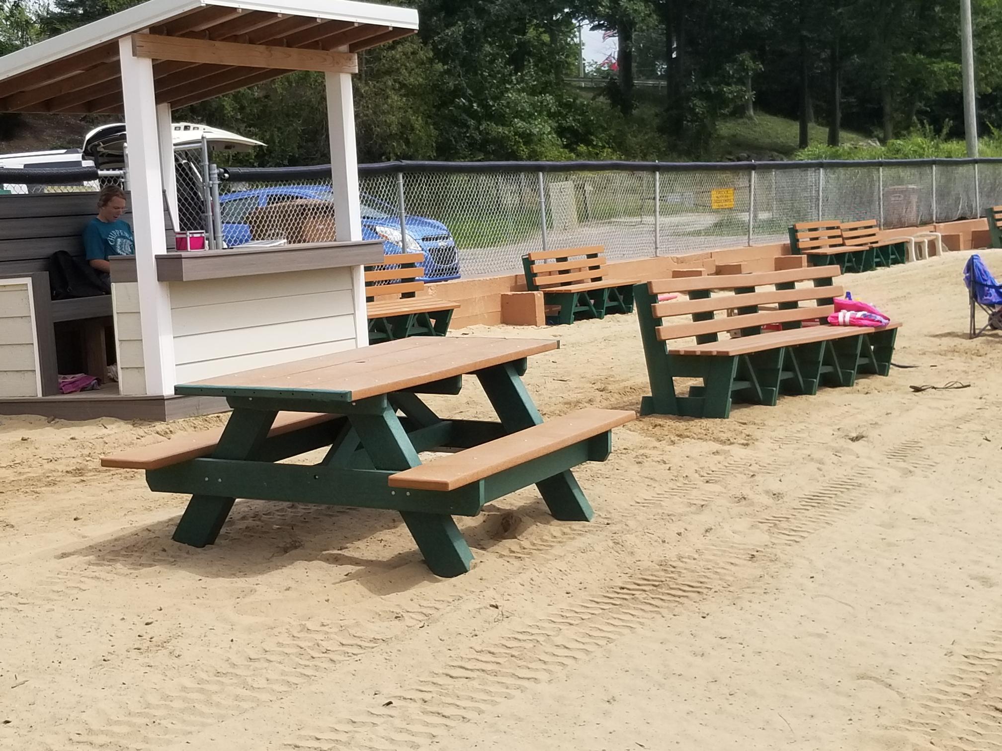 Mom and Dad relax in beach furniture as a young girl plays in the sand.